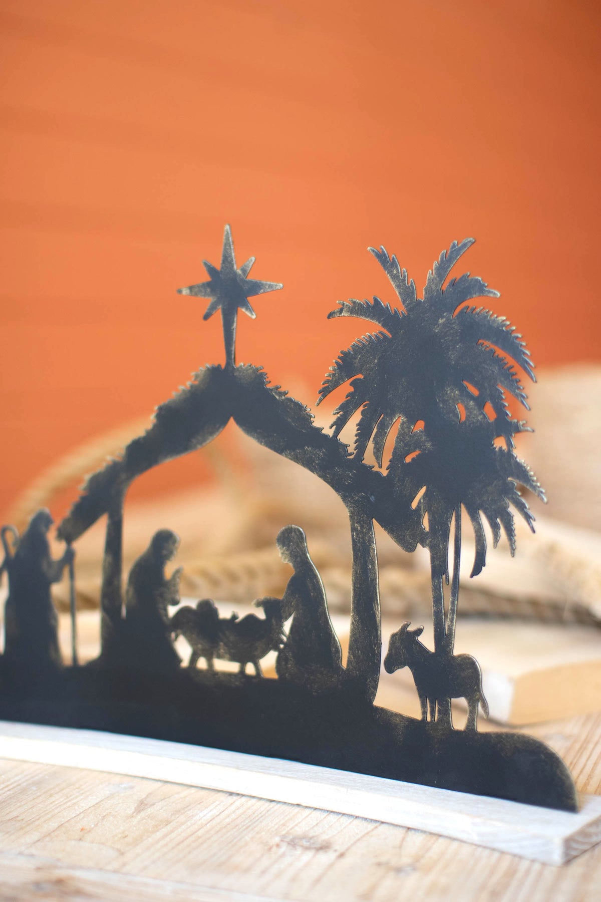 Black Metal Nativity on a Curved White Wood Base