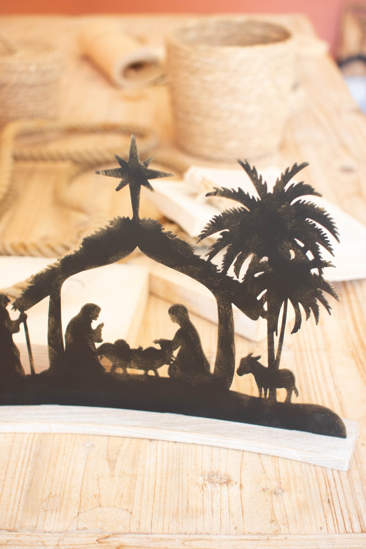 Black Metal Nativity on a Curved White Wood Base